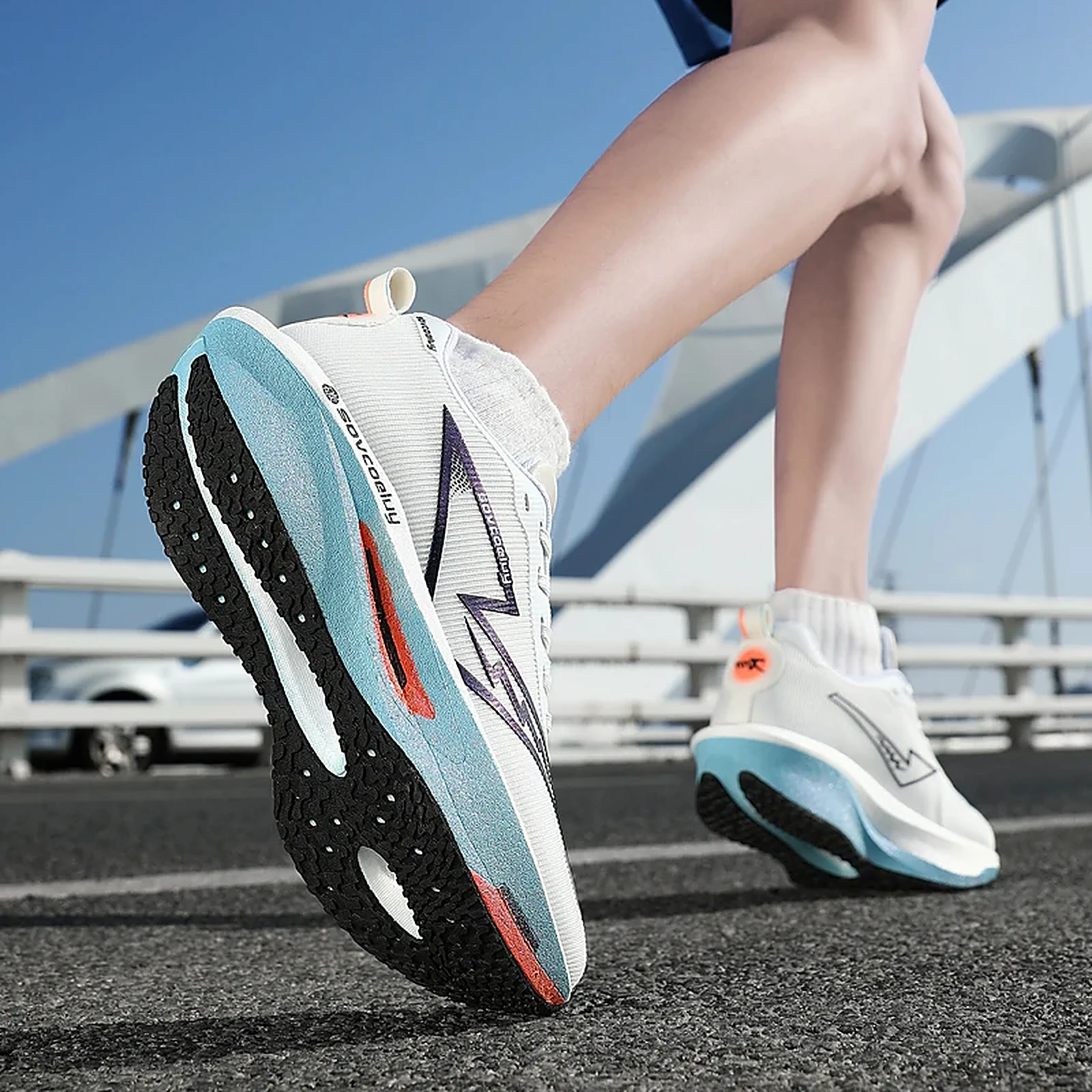 Runner wearing the white and blue Sovcoeluy Velocity Runner on a bridge
